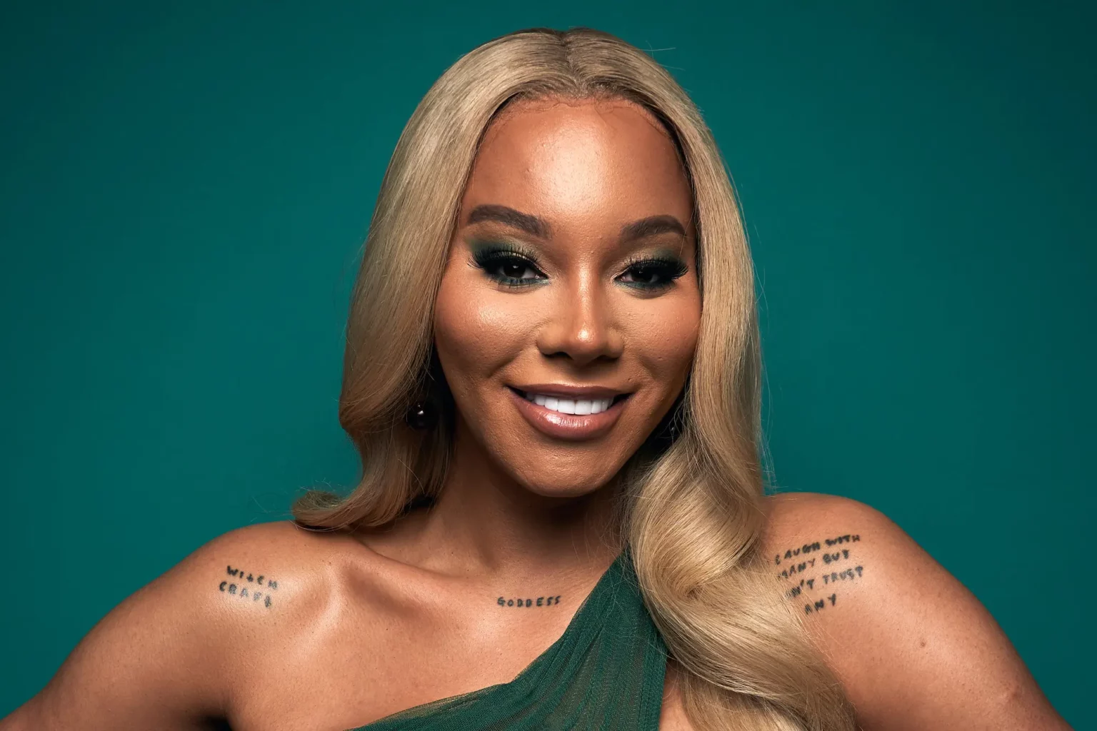 Model and activist Munroe Bergdorf poses smiling in front of a green background