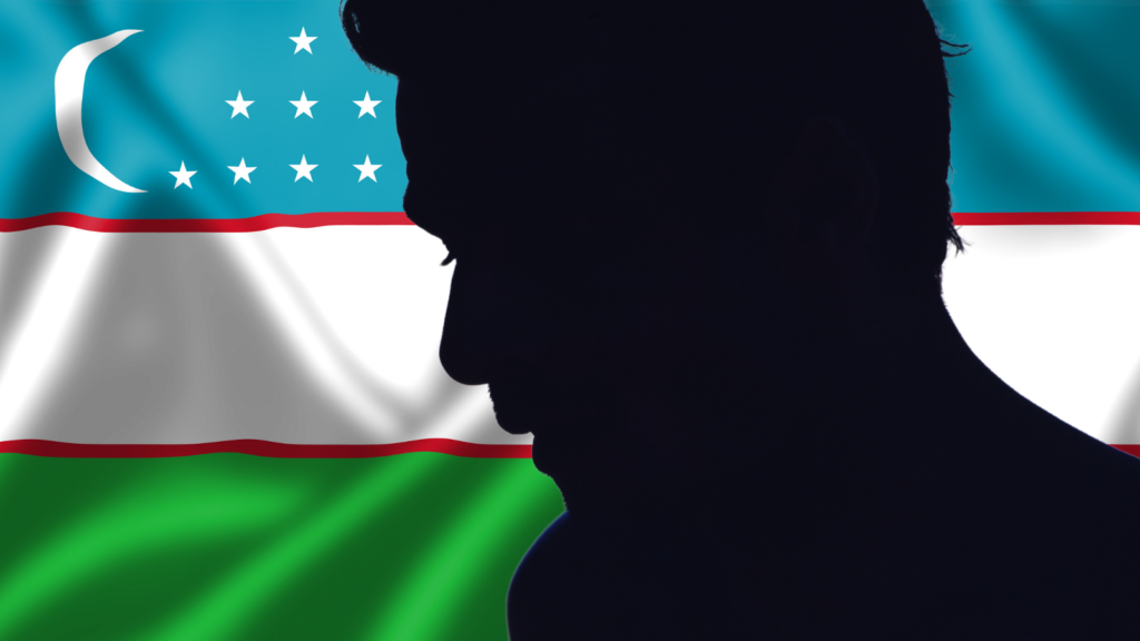 The profile of a man in silhouette against the Uzbek flag