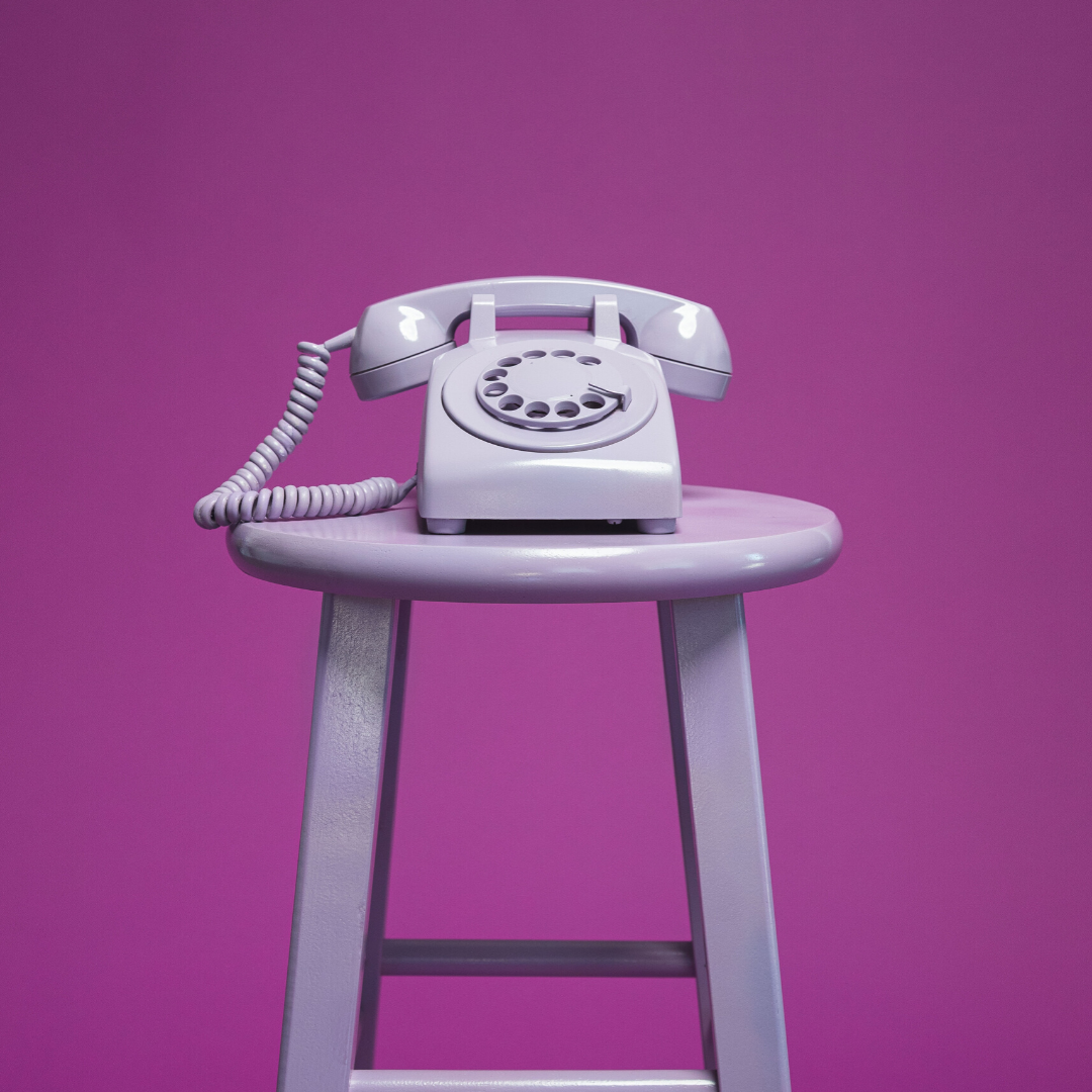 A landline on a chair before a purple background