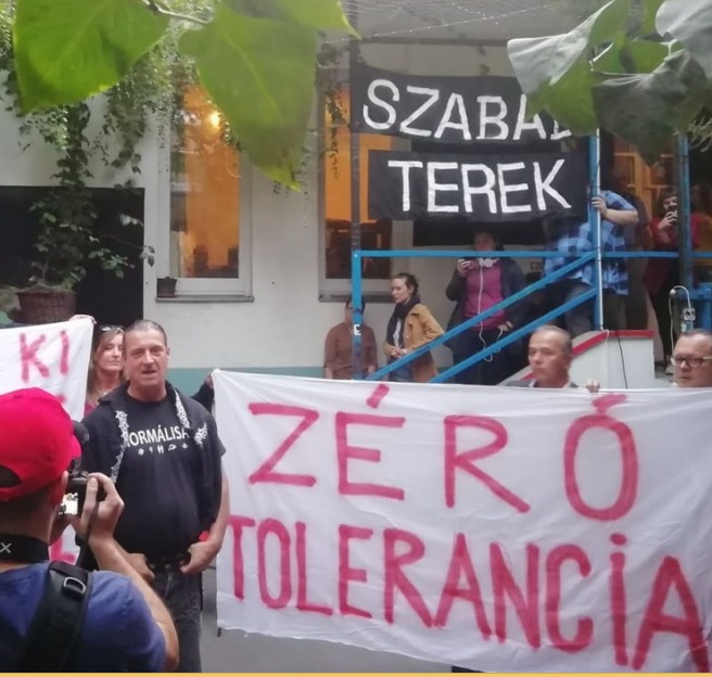 A group of anti-LGBTI protesters hold hateful signs in Budapest