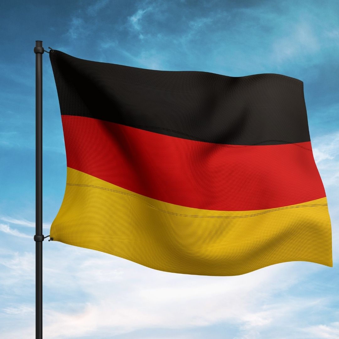 the german flag flies against a blue sky