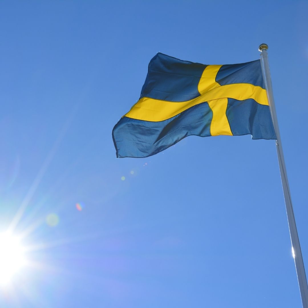 The flag of Sweden flies against a blue sky