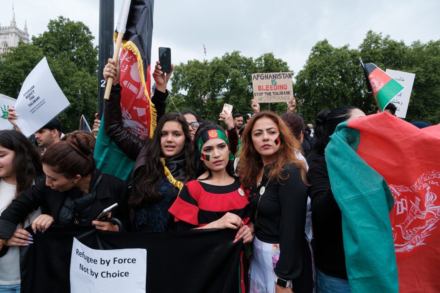 A moment of the Stop Killing Afghan Protest in London where 3 women are standing.