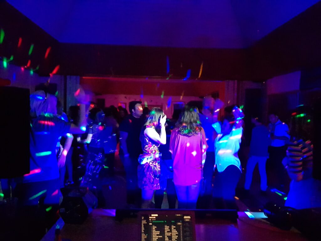 People dancing in disco lights at fundraising event