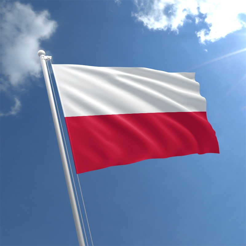 The Polish flag flies against a blue sky