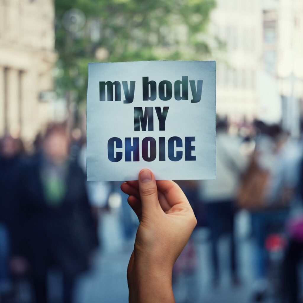A hand holds a sign saying 'My body, my choice'