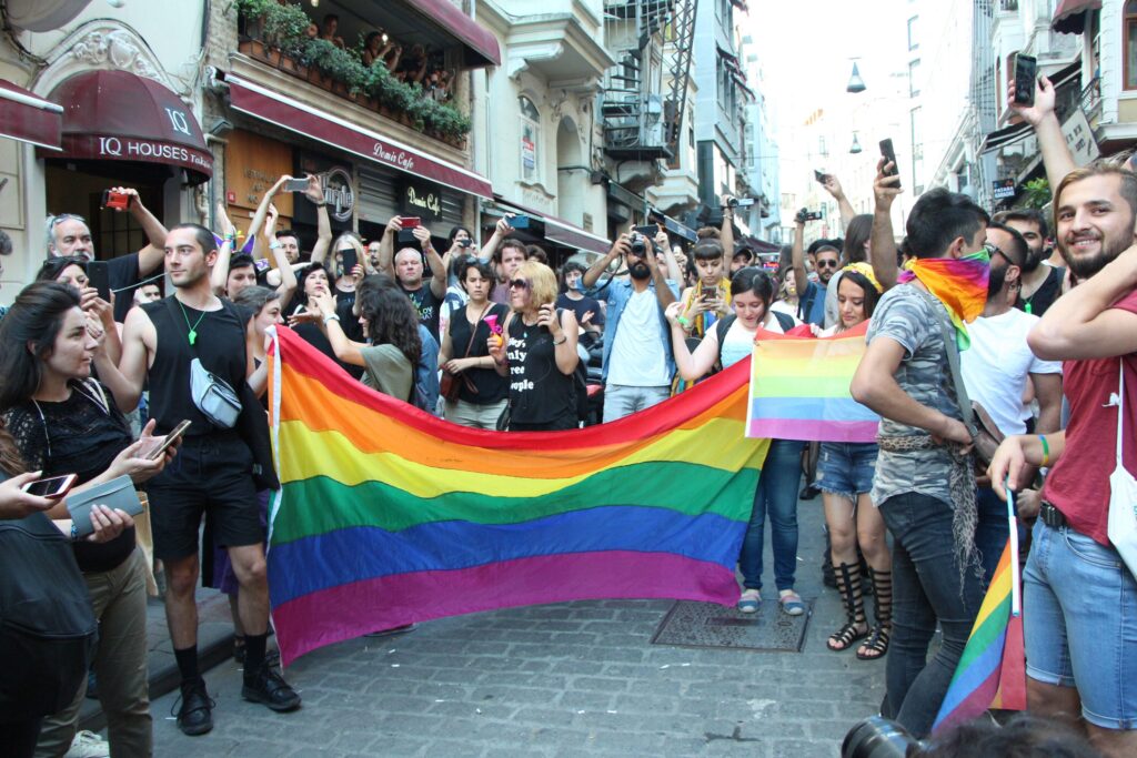 A group of people holding and flying rainbow flags and taking photos in Istanbul's Pride in 2018