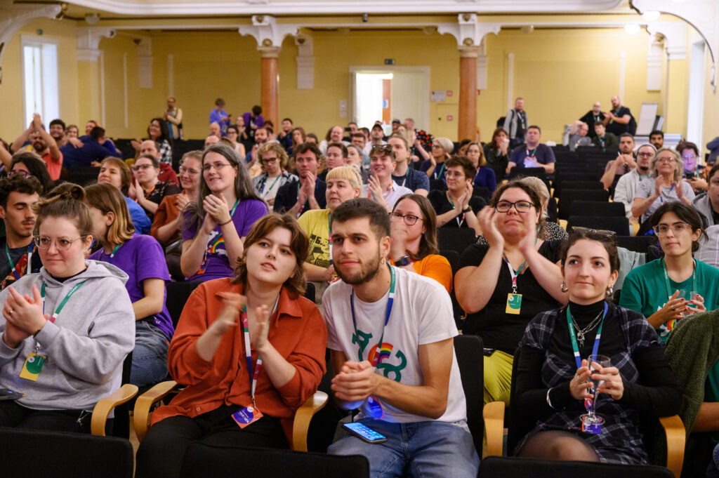 A group of people in the audience at the conference applauding