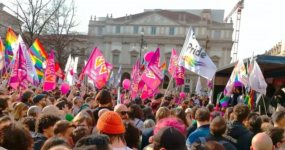 A group of people in Rome protest with pink flags