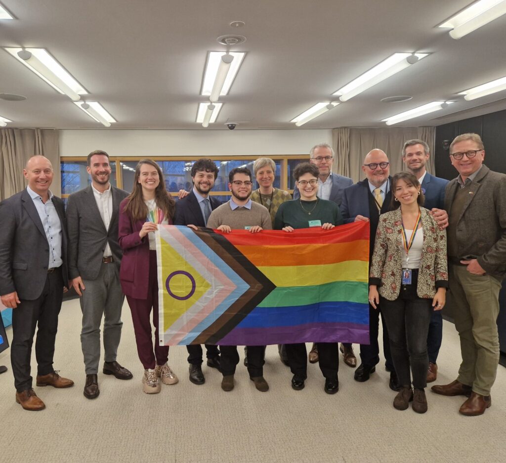 A group of candidates for the European Elections posing with a rainbow flag.