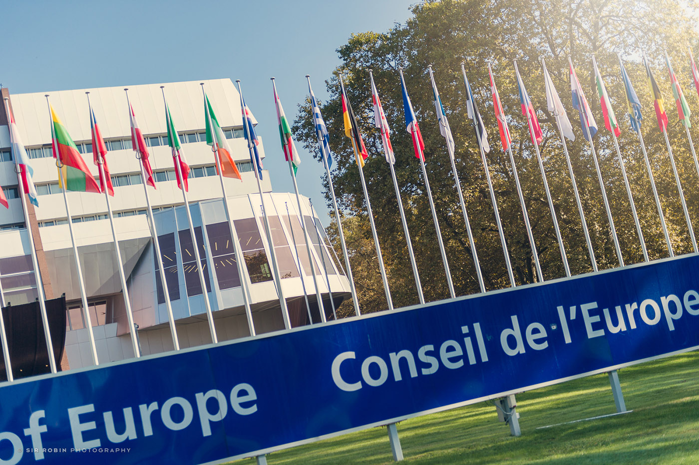 A photo of a building of Council of Europe, featuring various flags in the front.