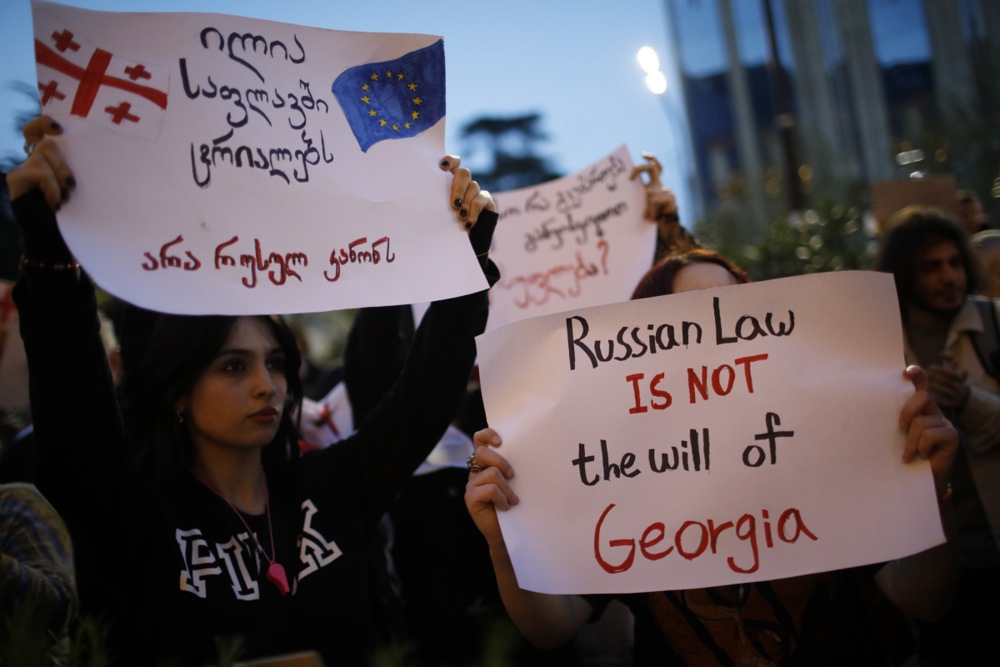 Activists holding up a sign saying "Russian law is not the will of Georgia".