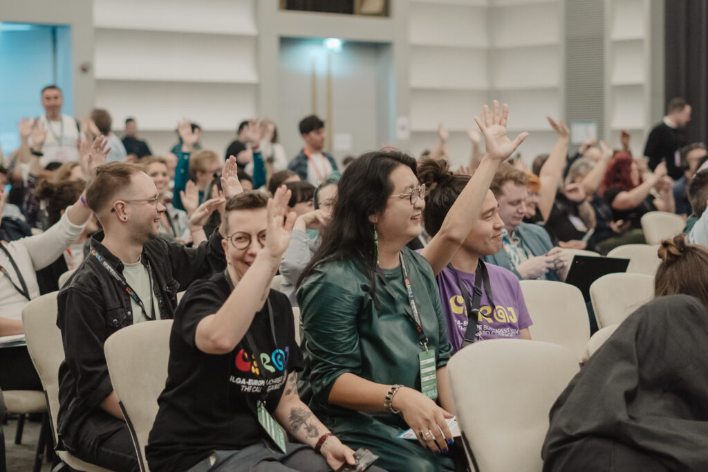 A photo of conference participants raising their hands