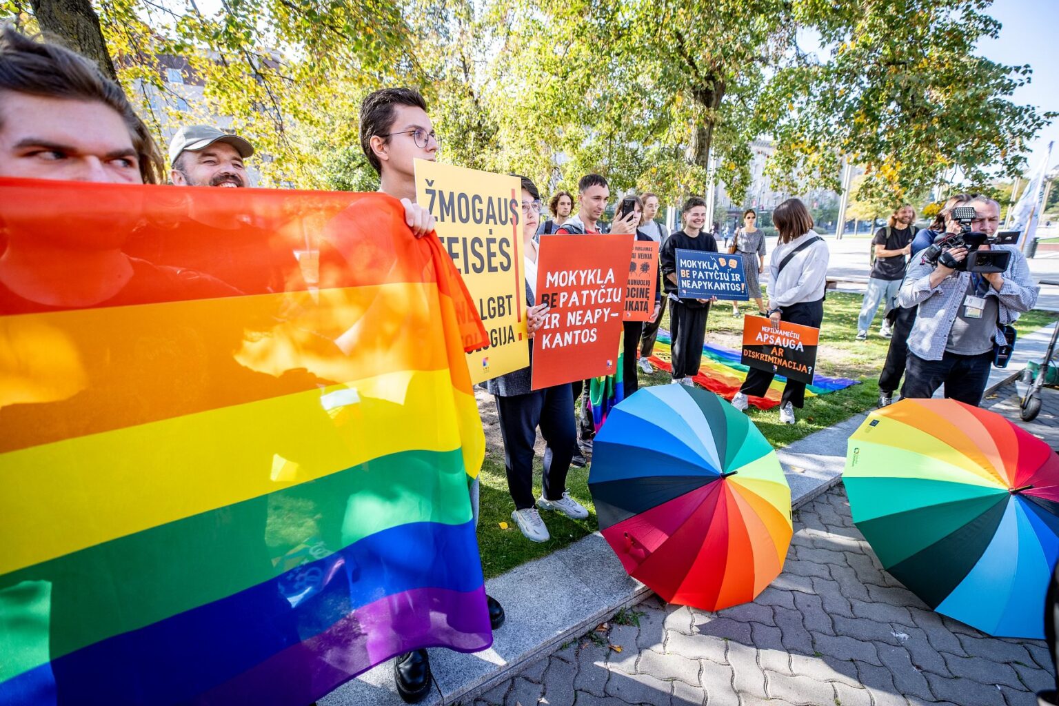 Lithuanian activists demonstrating with rainbow flags and signs.