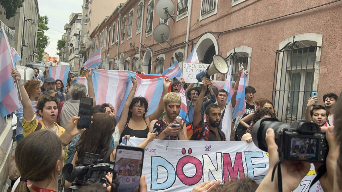 A photo of participants of a protest in Turkey, holding trans flags.